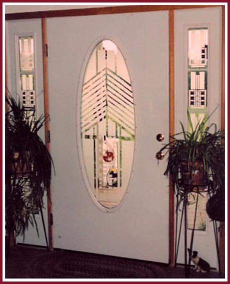 An oval etched glass entry door and rectangular side windows created using Egress Etch glass etching stencils